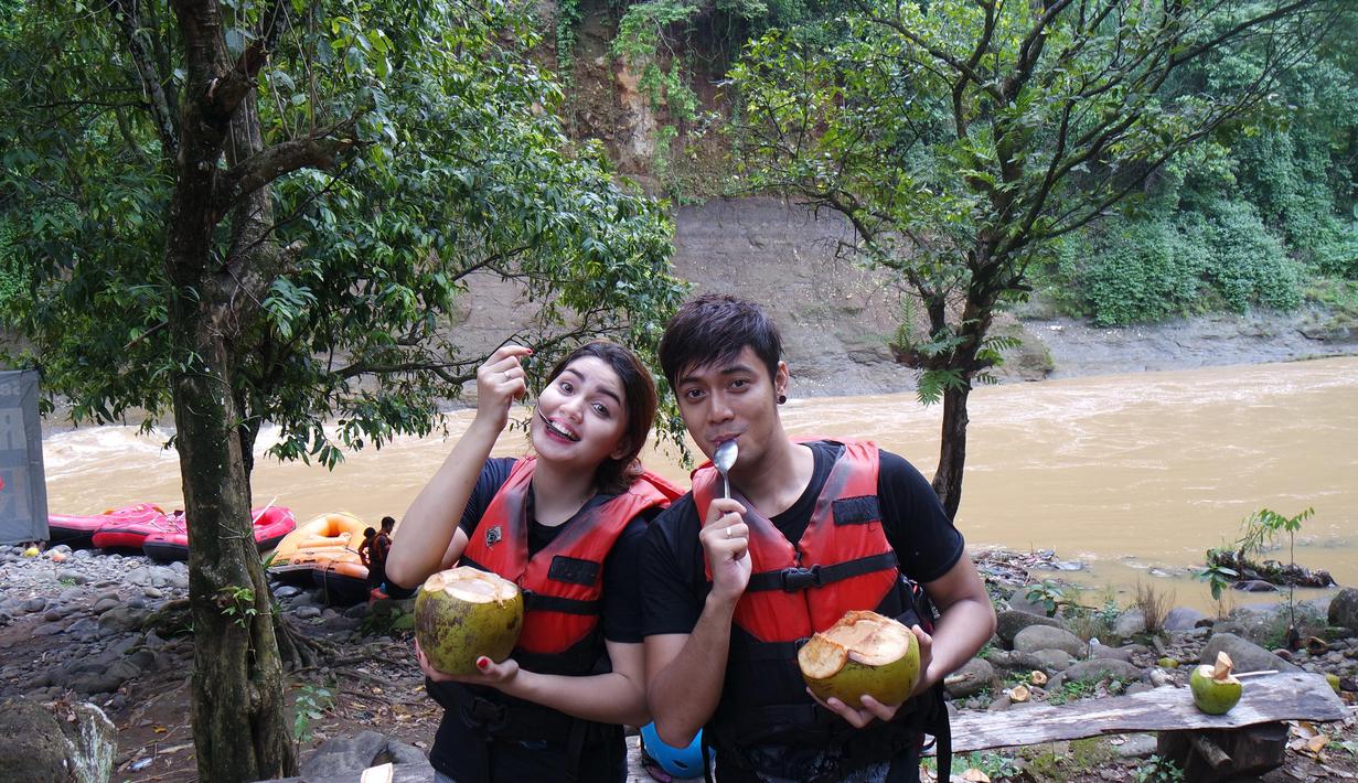 Krisshatta Luis Aveiro (kanan) dan Hilda Vitria Khan yang biasa tampil di sinetron dan FTV ini bersantai saat jeda arung jeram di Sungai Cicatih, Sukabumi, Sabtu (12/12/2015). (Bola.com/Arief Bagus)