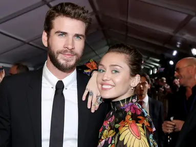 Kemesraan Miley Cyrus dan Liam Hemsworth di karpet merah premier film 'Thor: Ragnarok' di California, 10 Oktober 2017. Miley terlihat begitu manja saat meletakkan kepalanya di pundak pemain film THE HUNGER GAMES itu. (Rich Polk/Getty Images/AFP)