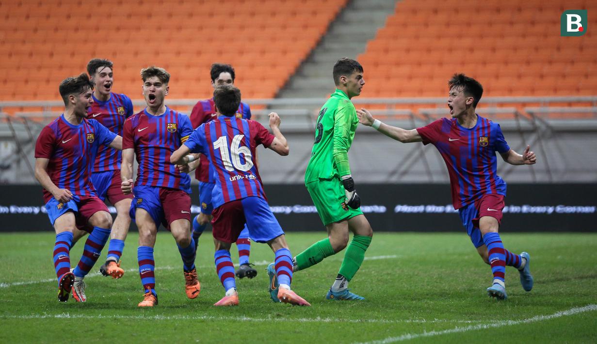 Pemain Barcelona U-18 melakukan selebrasi usai kiper Aron Yaakobishvili (kanan kedua) menggagalkan dua kali penalti saat laga International Youth Championship 2021 melawan Atletico Madrid U-18 di Jakarta International Stadium, Jakarta, Jumat (15/04/2022). (Bola.com/Bagaskara Lazuardi)