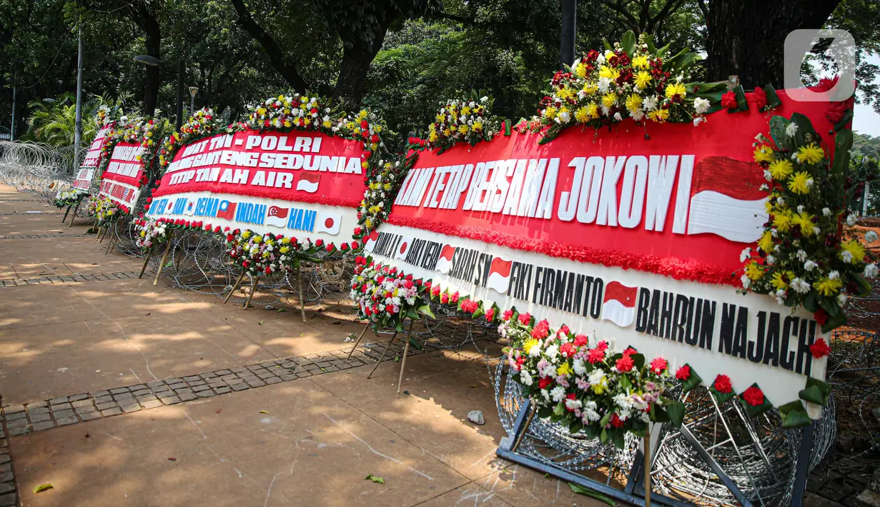 Sejumlah karangan bunga menghiasi kawasan Patung Kuda, Jakarta, Kamis (15/10/2020). Karangan bunga tersebut merupakan apresiasi masyarakat kepada TNI-Polri yang telah menjaga keamanan saat demo. (Liputan6.com/Faizal Fanani)
