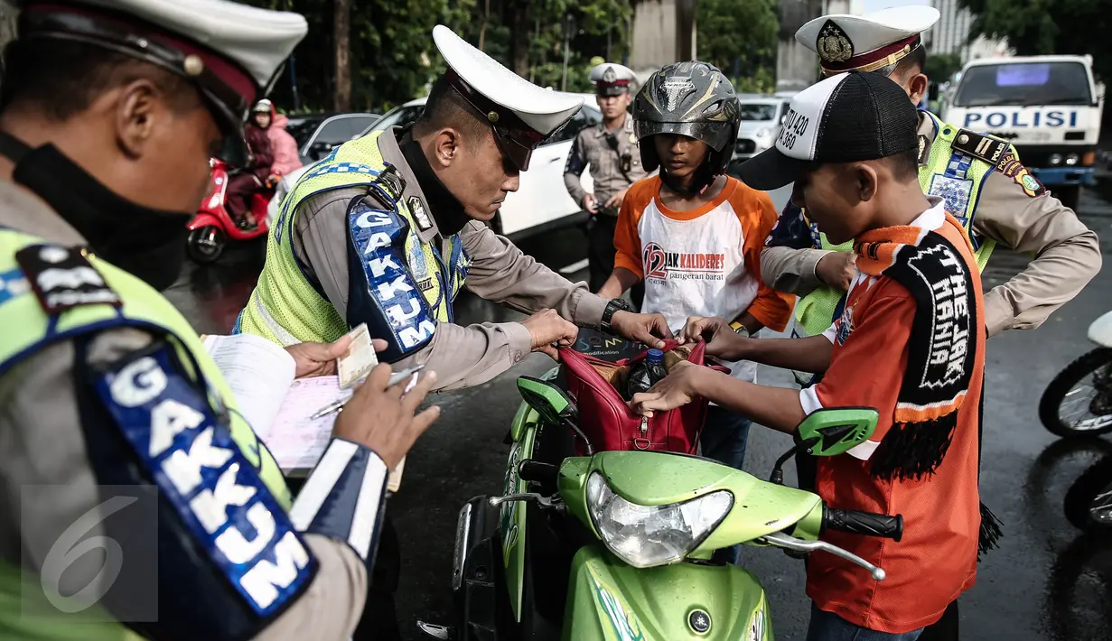 Petugas kepolisian merazia  suporter yang membawa barang berbahaya disekitar kawasan Gelora Bung Karno, Jakarta, Minggu (8/5/2016). Razia tersebut dilakukan untuk mengatisipasi keributan antar supporter. (Liputan6.com/Faizal Fanani)