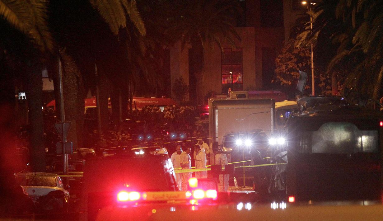 Petugas forensik berkumpul di lokasi ledakan sebuah bus yang mengangkut pengawal Presiden Tunisia di Tunis, Selasa (24/11). Insiden yang diduga akibat serangan bom bunuh diri itu menewaskan 12 orang dan melukai 16 lainnya. (AFP PHOTO/ KHALIL MOHAMED)