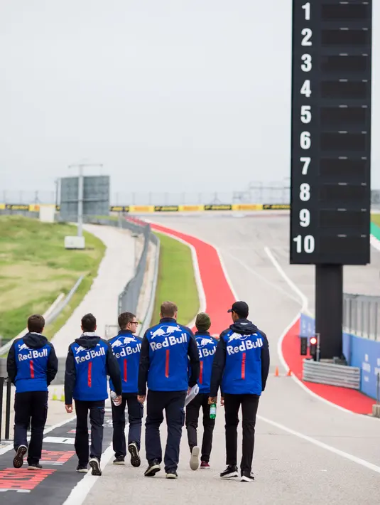 Pembalap Indonesia dari tim Scuderia Toro Rosso, Sean Geleal (kanan) berjalan bersama rekan-rekannya selama pratinjau menjelang Grand Prix F1 AS di Austin (18/10). Dikabarkan Sean Gelael berlaga di F1 2019 menemani Daniil Kvyat. (AFP Photo/Peter Fox)