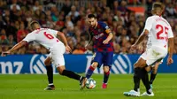 Bintang Barcelona, Lionel Mess mengontrol bola dibayangi pemain Sevilla dalam pertandingan pekan kedelapan kompetisi La Liga Spanyol 2019-2020 di Camp Nou, Minggu (6/10/2019). Barcelona berhasil menang telak atas Sevilla dengan skor 4-0. (AP Photo/Joan Monfort)