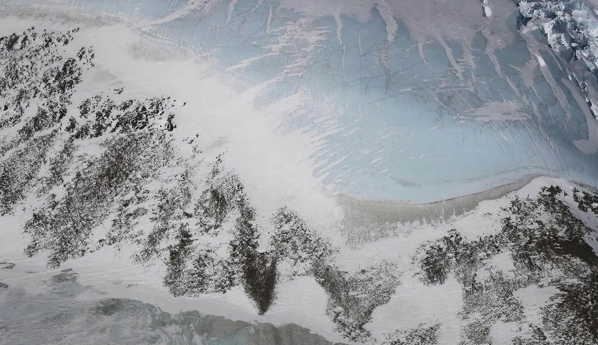Kondisi Es Biru di sepanjang punggung bukit Semenanjung Antartika (31/10). Operasi IceBridge yang dilakukan peneliti NASA berhasil menggambarkan kondisi es di Antartika lewat foto yang diambil dari pesawat Lockheed P-3 1966. (Mario Tama/Getty Images/AFP)