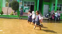 Banjir di ruang kelas dan guru kini mulai surut. Siswa bersama guru sibuk membersihkan lumpur di ruang kelas.