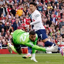 Pemain Tottenham Hotspur Son Heung-min mencetak gol ke gawang Arsenal yang dijaga oleh David Raya pada pertandingan sepak bola Liga Inggris di Emirates Stadium, London, Inggris, Minggu (24/9/2023). Pertandingan berakhir imbang dengan skor 2-2. (AP Photo/David Cliff)