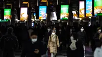 Orang-orang yang memakai masker berjalan di stasiun Shinagawa di Tokyo (18/1/2022). Jepang melaporkan rekor tertinggi infeksi Covid-19 baru yang dipicu oleh varian Omicron. (AFP/Philip Fong)