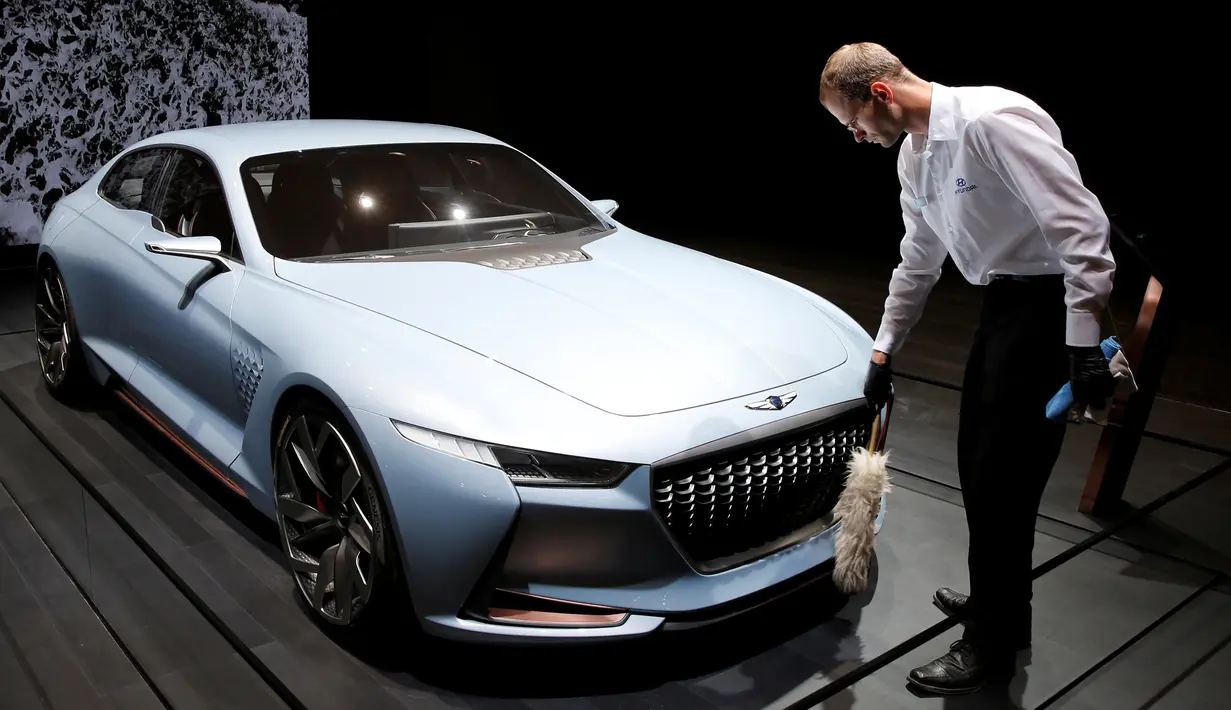 Seorang pekerja membersihkan mobil Genesis New York Concept saat ditampilkan di Paris Auto Show di Paris, Prancis (29/9). (REUTERS/Benoit Tessier)