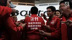 Calon legislatif dari Partai Solidaritas Indonesia (PSI) mendatangi gedung DPR RI di Senayan, Jakarta, Jumat (7/12). Kedatangan mereka untuk kampanye bersih-bersih DPR sambil mengenakan seragam merah ala cleaning service. (Liputan6.com/Johan Tallo)