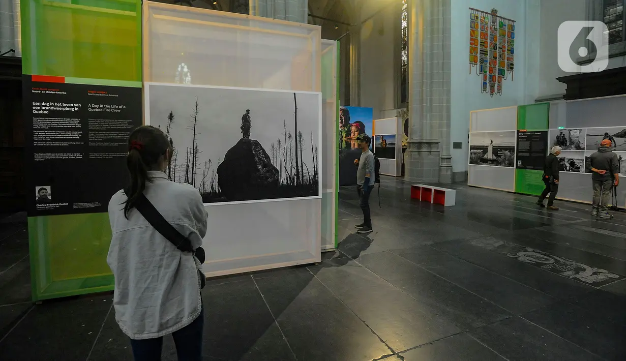 Pengunjung mengamati karya foto pemenang World Press Photo (WPP) 2024 di De Nieuwe Kerk Amsterdam, Belanda, Rabu (22/5/2024). (merdeka.com/Arie Basuki)