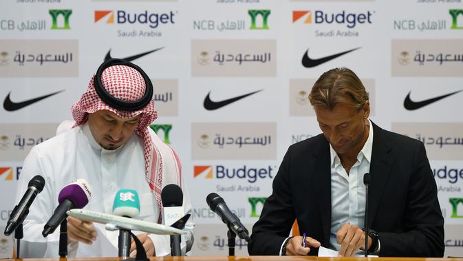 Pelatih asal Prancis, Herve Renard (kanan) didampingi ketua Federasi Sepakbola Saudi Yasser Almisehal saat menandatangani dokumen setelah resmi menjadi pelatih Timnas Arab Saudi di Jeddah (5/8/2019).  (AFP Photo/Amer Hilabi)