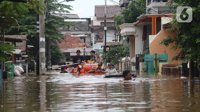 Petugas membantu warga yang terjebak banjir di perumahan Ciledug Indah, Tangerang, Rabu (1/1/2020). Banjir setinggi dada orang dewasa terjadi akibat meluapnya kali angke. (Liputan6.com/Angga Yuniar)
