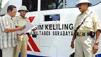 Anggota Satlantas Polwiltabes Surabaya melayani pemohon perpanjangan SIM dengan mengenakan kostum ala pejuang kemerdekaan, Senin (17/8). (Antara)