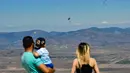 Orang-orang menyaksikan sejumlah pemain paralayang terbang dalam kegiatan luar ruangan dekat Krusevo, Makedonia Utara, pada 2 Agustus 2020. (Xinhua/Tomislav Georgiev)