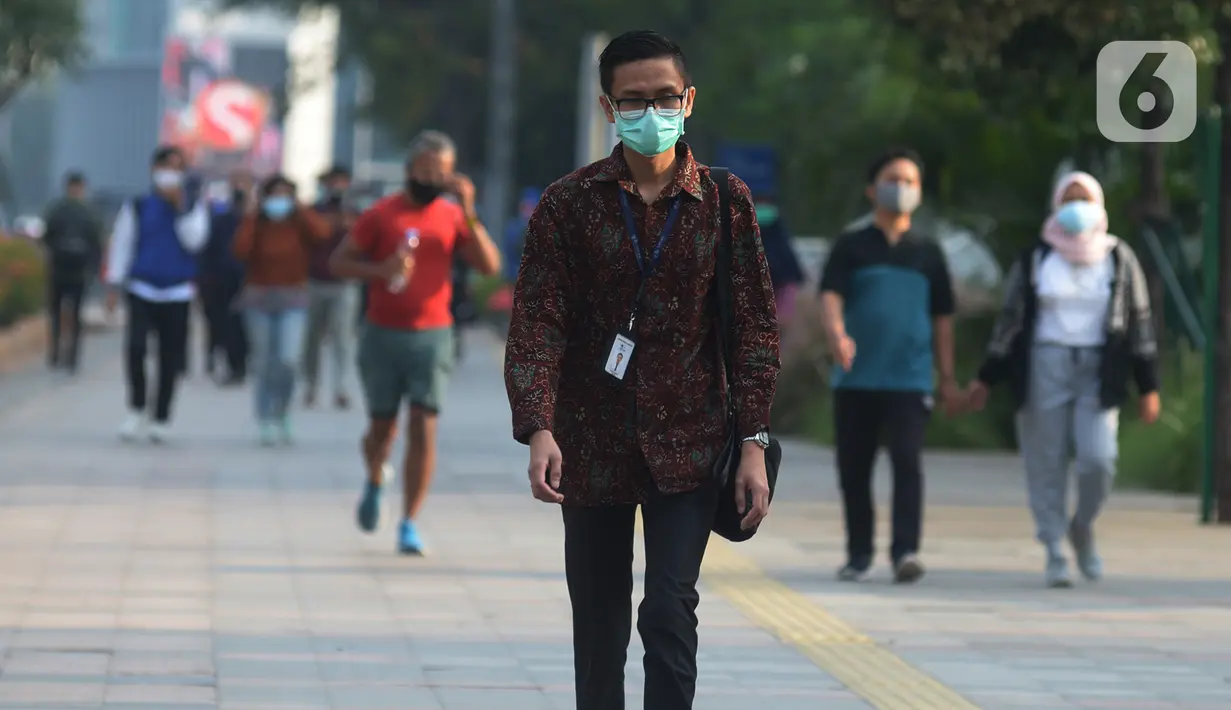Seorang pria yang mengenakan baju batik berjalan di kawasan Thamrin Sudirman, Jakarta, Jumat (2/10/2020). Pada Hari Batik Nasional yang berlangsung di tengah pandemi COVID-19, sebagian masyarakat terlihat mengenakan baju dan masker dengan motif batik. (merdeka.com/Imam Buhori)