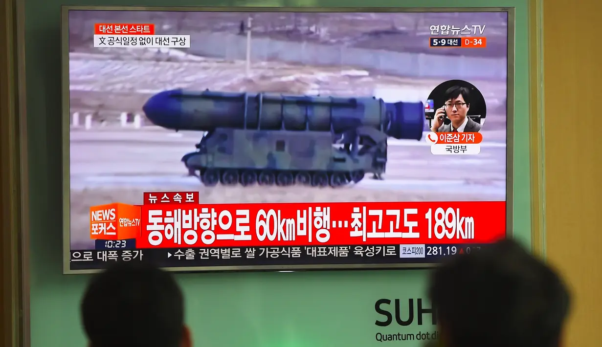 Layar televisi menyiarkan berita terkait Korea Utara yang menembakkan rudal ke arah Laut Jepang, di stasiun kereta Seoul, Selasa (5/4). Tembakan dilancarkan jelang pertemuan antara Presiden AS Donald Trump dan Presiden China Xi Jinping. (JUNG Yeon-Je/AFP)