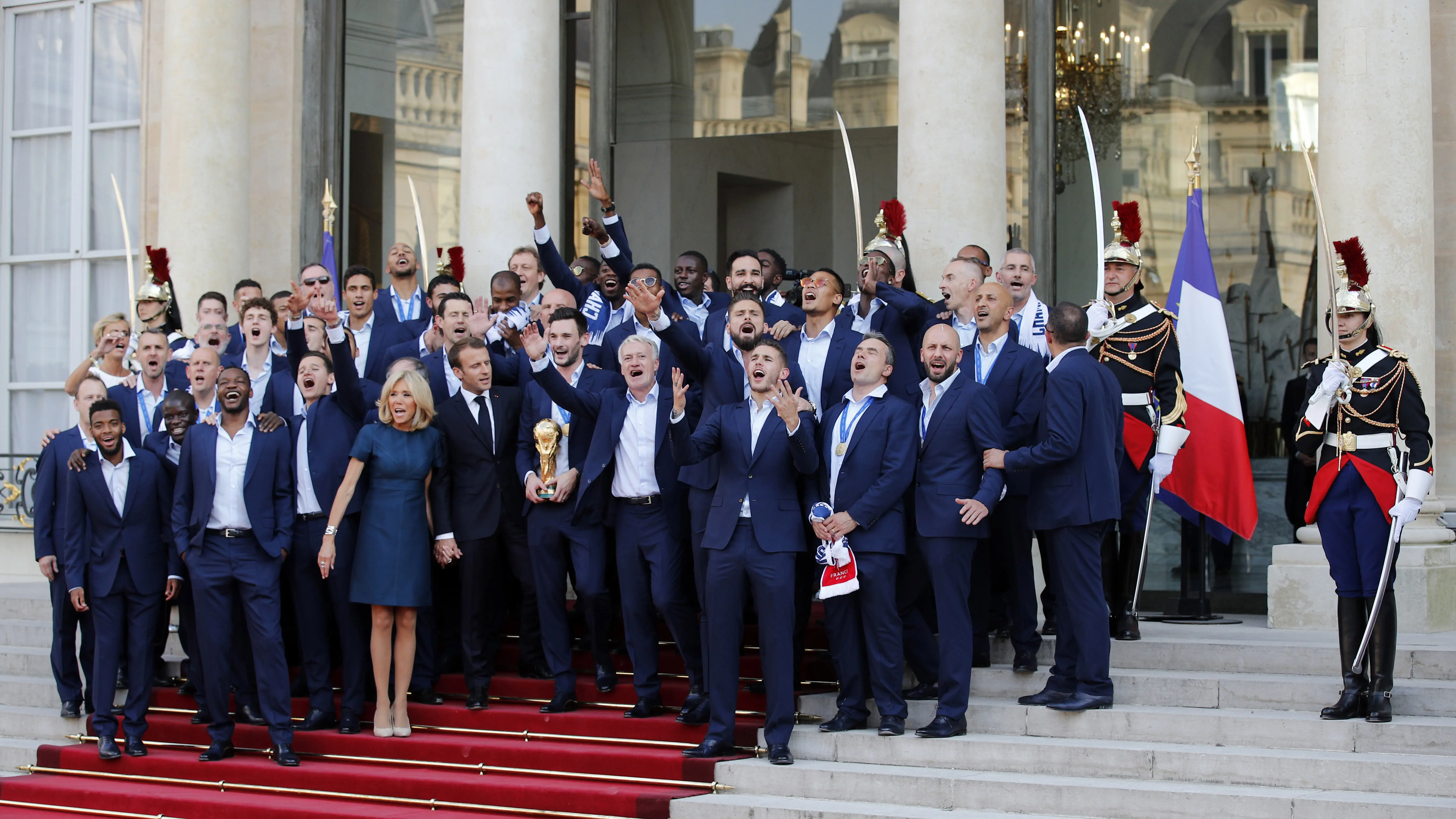 Presiden Prancis, Emmanuel Macron beryanyi bersama pemain dan official Les Bleus di Elysee Presidential Palace, Paris, (16/7/2018). Prancis berpesta merayakan keberhasilan Les Bleus meraih trofi Piala Dunia 2018. (AP/Francois Mori)