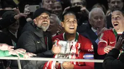 Pelatih Liverpool, Jurgen Klopp (tengah kiri) dan Virgil Van Dijk berisap mengangkat trofi Carabao Cup 2023/2024 di Stadion Wembley, Inggris, Minggu (25/02/2024). The Reds menang atas Chelsea dengan skor 1-0 melalui gol Virgil Van Dijk pada menit ke-118. (AP Photo/Dave Shopland)