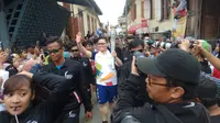 Niko Kwee, Ketua Astra Grup Palembang membawa obor Asian Games 2018 berkeliling Kampung Almunawar Palembang (Liputan6.com / Nefri Inge)