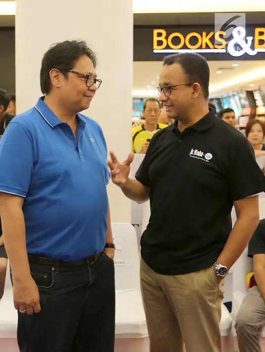 Gubernur DKI Jakarta Anies Baswedan berbincang dengan Ketum Partai Golkar sekaligus Menteri Perindustrian Airlangga Hartarto di Pluit Village Mall, Jakarta, Minggu (29/7). Anies dan Airlangga hadir bersama putranya. (Liputan6.com/Fery Pradolo)