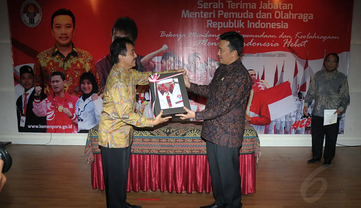 Roy Suryo (kiri) secara resmi menyerahkan seragam kantor Kementerian Pemuda dan Olahraga kepada Menpora Imam Nahrawi saat upacara serah terima jabatan di Wisma Kemenpora, Jakarta, Rabu (29/10/2014). (Liputan6.com/Helmi Fithriansyah)