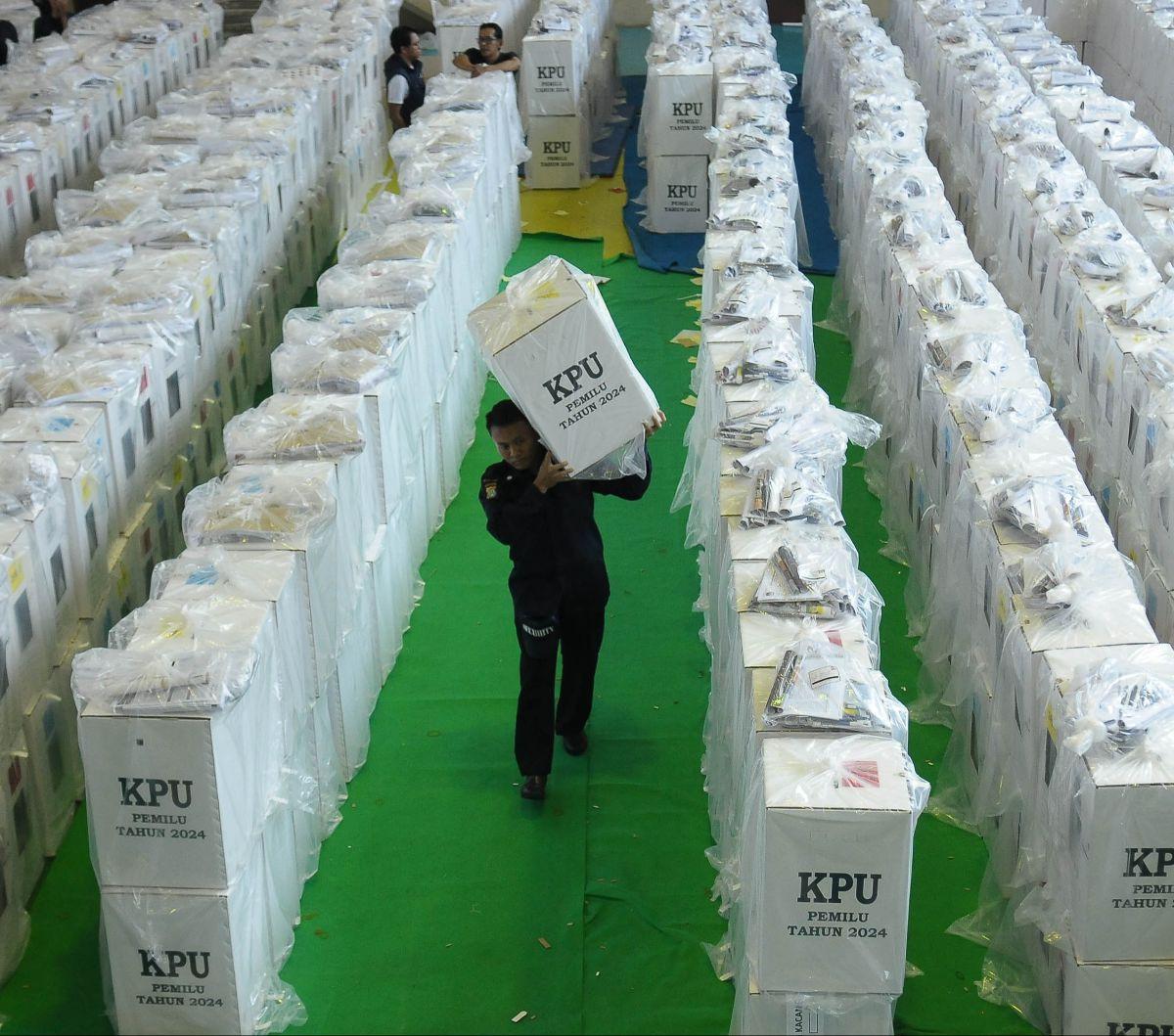 Petugas mengeluarkan logistik Pemilu 2024 dari GOR Tanah Abang untuk didistribusikan ke sejumlah Tempat Pemungutan Suara (TPS), Selasa (13/2/2024). Logistik pemilu&nbsp;berupa kotak suara, bilik suara, alat coblos dan bantalan ini akan disebar ke&nbsp;498