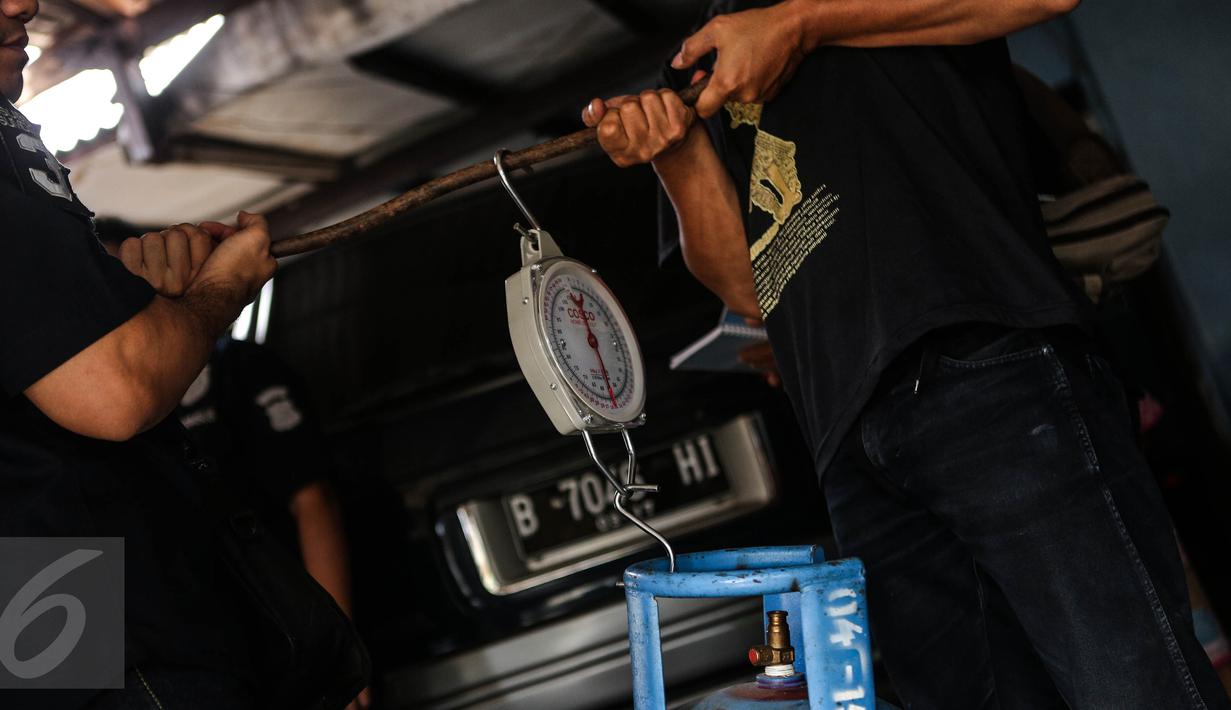 Petugas Krimsus Polda Metro Jaya menimbang tabung gas elpiji 12 kg di kawasan Kebon Jeruk, Jakarta, Kamis (30/7/2015). Kasus ini bermula dari laporan warga ketika mengembalikan tabung gas yang diduga berisi air ke penjual. (Liputan6.com/Faizal Fanani)