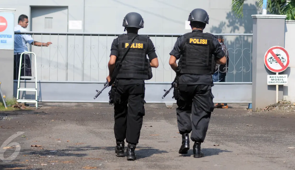 Dua anggota polisi bersenjata laras panjang berjalan menuju pintu masuk dermaga Wijayapura, Cilacap, Jateng, Kamis (28/7). 1.466 personel gabungan disiagakan untuk melakukan pengamanan eksekusi mati tahap III di Nusakambangan. (Liputan6.com/Helmi Afandi)