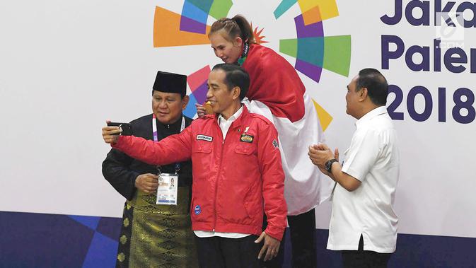 Presiden Joko Widodo bersama Ketua Umum Pengurus Besar Ikatan Pencak Silat Indonesia (IPSI) Prabowo Subianto usai mengalungkan medali kepada atlet di final pencak silat Asian Games 2018, Jakarta Jakarta, Rabu (29/8). (Merdeka.com/Imam Buhori)