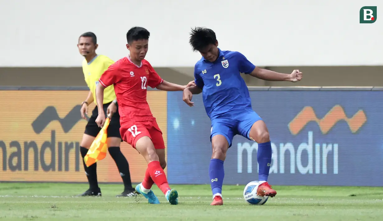 <p>Bek Timnas Thailand U-16, Phuriphan Phothong (kanan) berusaha mengontrol bola dibayangi striker Timnas Vietnam U-16, Nguyen Thai Hieu pada laga semifinal Piala AFF U-16 2024 di Stadion Manahan, Solo, Senin (1/7/2024). (Bola.com/Abdul Aziz)</p>