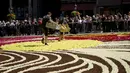 Para sukarelawan bekerja menempatkan bunga begonia ke dalam karpet bunga raksasa bertema Art Nouveau di Grand Place yang bersejarah di Brussels, Belgia, Kamis, 15 Agustus 2024. (AP Photo/Virginia Mayo)