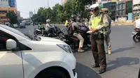 Polisi menindak pelanggar aturan ganjil genap di Jalan Hayam Wuruk dan Jalan Gajah Mada, Jakarta Barat. (Liputan6.com/Ratu Annisa)