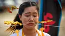 Seorang wanita menusuk pipinya dengan besi  saat mengikuti prosesi perayaan Festival Vegetarian tahunan di Phuket, Thailand, Kamis (3/10/2019). Festival menyiksa diri ini dipercaya bagi warga Phuket akan mendapat kesehatan dan ketenangan pikiran. (AFP Photo/Mladen Antonov)