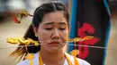 Seorang wanita menusuk pipinya dengan besi  saat mengikuti prosesi perayaan Festival Vegetarian tahunan di Phuket, Thailand, Kamis (3/10/2019). Festival menyiksa diri ini dipercaya bagi warga Phuket akan mendapat kesehatan dan ketenangan pikiran. (AFP Photo/Mladen Antonov)