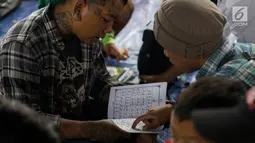 Anak punk saat belajar mengaji di kolong flyover Tebet, Jakarta, Sabtu (8/12). Dengan konsep persahabatan, komunitas ini mengajak anak-anak punk dan anak jalanan menyiapkan diri untuk kembali masuk ke dalam masyarakat. (Merdeka.com/Imam Buhori)