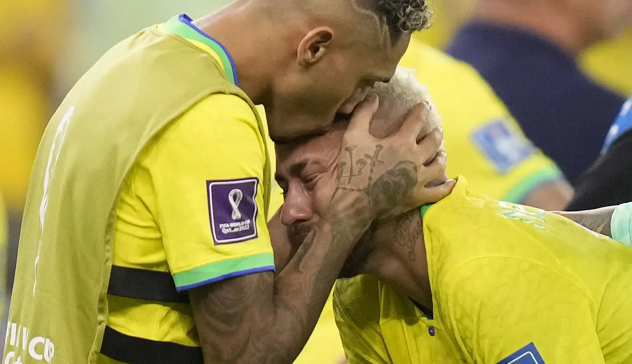 Pemain Brasil, Neymar (kanan) dihibur oleh rekannnya, Raphinha setelah tim mereka kalah dari Kroasia saat laga perempat final Piala Dunia Qatar 2022 yang berlangsung di Education City Stadium, Al-Rayyan, Jumat (09/12/2022) waktu setempat. Brasil kalah 2-4 dari Kroasia saat babak adu penalti. (AP/Darko Bandic)