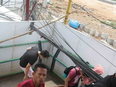 Pejalan kaki melintasi jembatan penyeberangan orang yang terhalang instalasi kabel di Depok, Jawa Barat, Sabtu (8/12). Selain mengganggu kenyamanan, keberadaan instalasi kabel semrawut tersebut membahayakan pejalan kaki. (Liputan6.com/Immanuel Antonius)