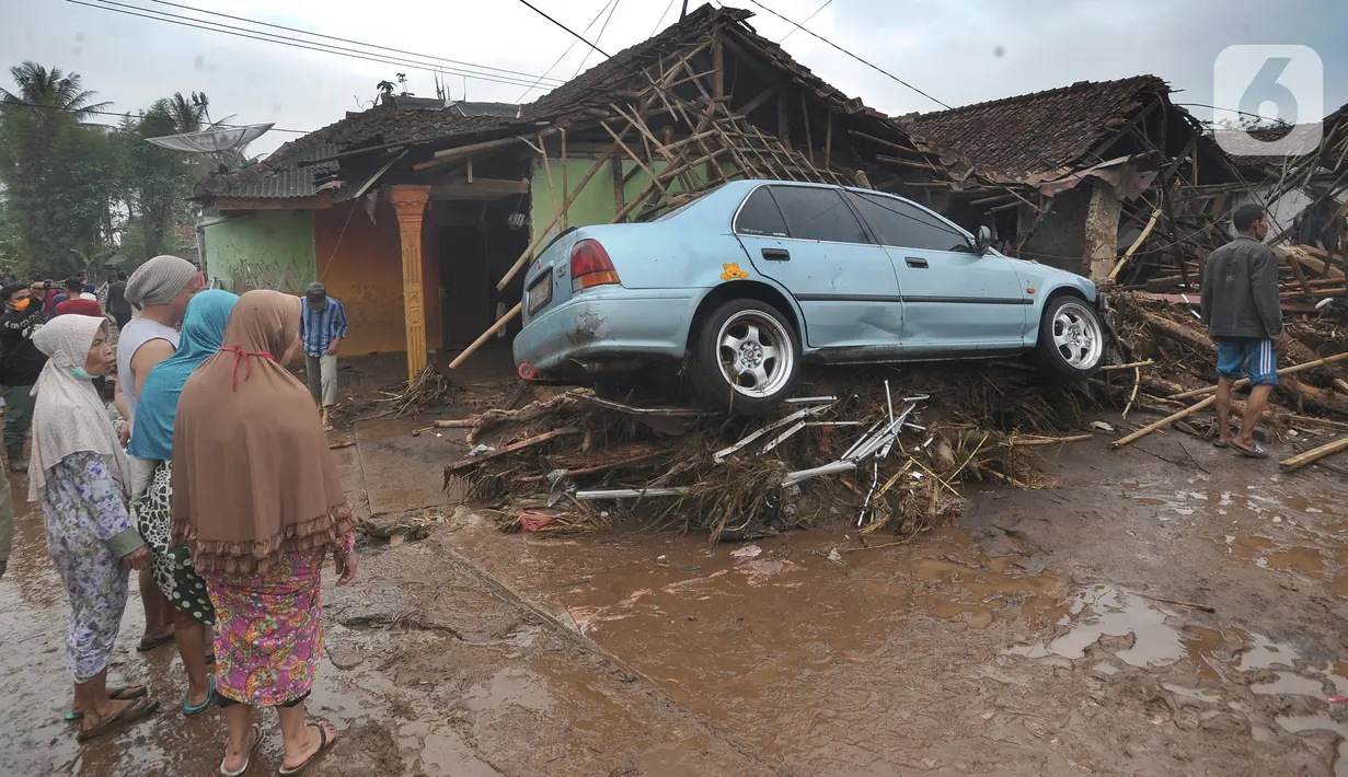 Warga menyaksikan bangunan yang rusak usai banjir bandang melanda Kampung Cibuntu, Desa Pasawahan, Kecamatan Cicurug, Sukabumi, Jawa Barat, Selasa (22/9/2020). Data sementara puluhan bangunan rusak berat, 12 rumah hanyut, dan dua korban hilang masih dicari. (merdeka.com/Arie Basuki)