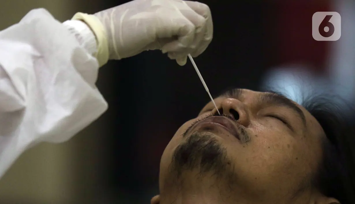 Petugas medis melaksanakan proses rapid test antigen pada salah satu pewarta di ruang wartawan Gedung KPK, Jakarta, Senin (16/11/2020). Rapid Test Antigen dilakukan untuk mendeteksi keberadaan virus SARS-CoV-2 penyebab Covid-19. (Liputan6.com/Helmi Fithriansyah)