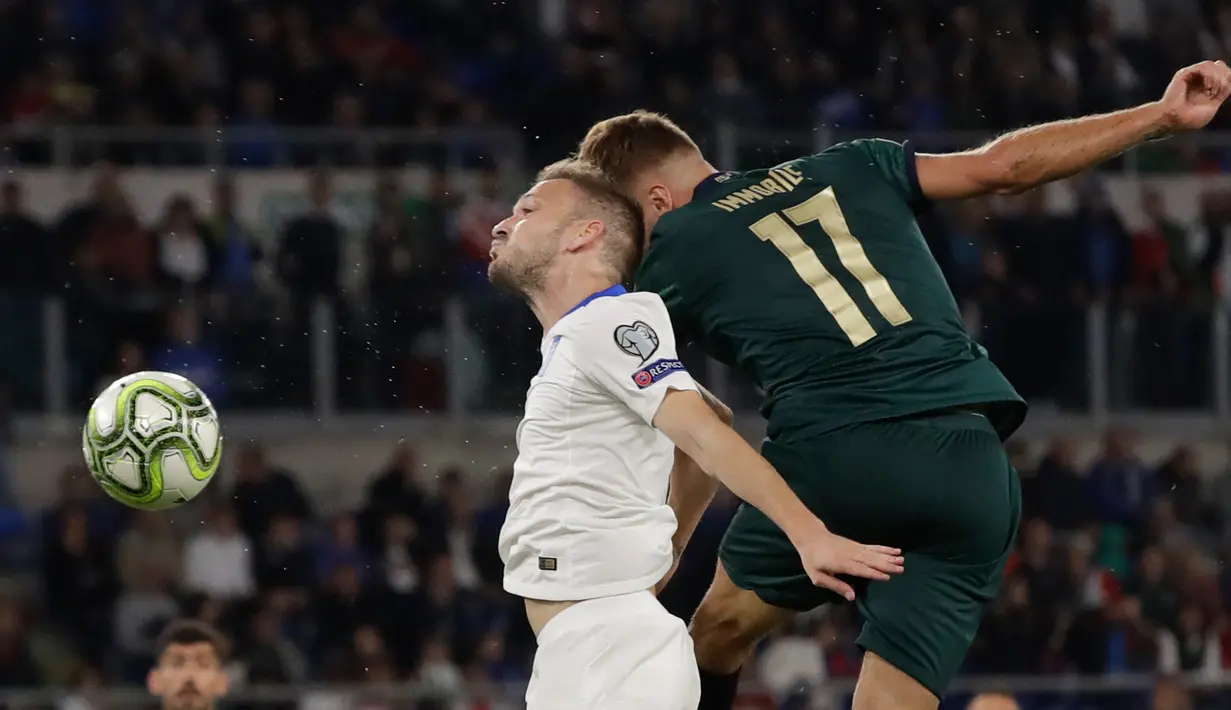 Striker timnas Italia, Ciro Immobile dan pemain timnas Yunani, Michalis Bakakis berebut bola pada pertandingan grup J babak kualifikasi Piala Eropa 2020 di Stadio Olimpico, Sabtu (12/10/2019). Timnas Italia memastikan satu tempat pada putaran final setelah menang 2-0. (AP/Alessandra Tarantino)
