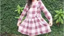 Plaid dress lengan panjang yang dipadu kaos kaki dan flat shoes juga tak kalah menarik.
