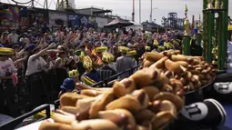 Acara Hari Kemerdekaan yang meriah ini mendatangkan ribuan orang ke Coney Island, New York, pada hari Selasa untuk menyaksikan para peserta lomba yang kompetitif melahap sebanyak mungkin hot dog hanya dalam waktu 10 menit. (AP Photo/Yuki Iwamura)