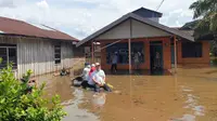 Petugas BPBD Kotawaringin Timur menyalurkan bantuan kepada keluarga yang masih bertahan di rumah yang tergenang banjir. (Foto: BPBD Kotim)