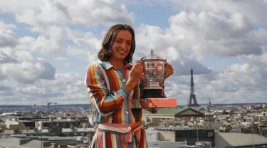 Petenis Polandia Iga Swiatek berpose dengan trofi juara Prancis Terbuka 2020 saat sesi foto di rooftop Galeries Lafayette, Paris, Prancis, Minggu (11/10/2020). Petenis berusia 19 tahun ini mencatatkan diri sebagai sosok Polandia pertama yang memenangkan Grand Slam. (AP Photo/Christophe Ena)