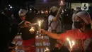 Massa menggelar aksi dengan membawa lilin dan doa bersama lintas agama di depan Gedung DPR, Jakarta, Kamis (16/3/2023). Dalam aksinya, mereka menuntut agar pimpinan DPR menetapkan RUU PPRT sebagai RUU INISIATIF DPR di Rapat Paripurna pada Selasa, 21 Maret 2023 mendatang. (Liputan6.com/Johan Tallo)