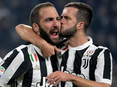 Pemain Juventus, Gonzalo Higuain dan rekan setimnya, Herzegovina Miralem Pjanic merayakan gol ke gawang SPAL pada lanjutan Serie A Italia di Allianz Stadium, Kamis (26/10). Juventus menang besar saat menjamu SPAL dengan skor 4-1. (MIGUEL MEDINA/AFP)