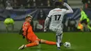 Gelandang Paris Saint-Germain (PSG) Eric-Junior Dina-Ebimbe (kanan) memainkan bola di sebelah kiper klub divisi empat, Vannes OC, Clement Petrel dalam babak 32 besar Piala Prancis di Stade de la Rabine, Selasa (4/1/2021) dini hari WIB. PSG menang 4-0 lewat hattrick Kylian Mbappe. (LOIC VENANCE/AFP)
