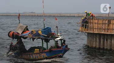 Pekerja menyelesaikan proyek tanggul pengaman pantai Kampung Nelayan Cilincing, Jakarta, Jumat (10/11/2023). (merdeka.com/Imam Buhori)