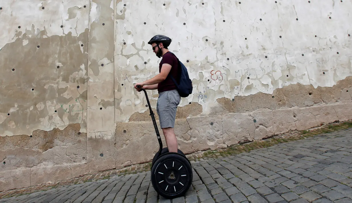 Seorang turis menggunakan segway di jalanan menurun di pusat kota Praha, Ceko, Selasa (19/7). Segway yang merupakan kendaraan personal listrik beroda 2 yang mampu menyeimbangkan sendiri itu kini menjadi favorit para turis. (REUTERS/David W Cerny)